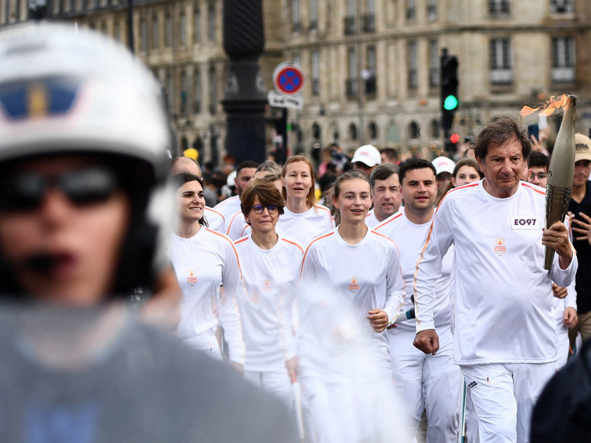 The torch bearer is escorted during the OlympicTorch Relay in Bordeaux. GETTY IMAGES