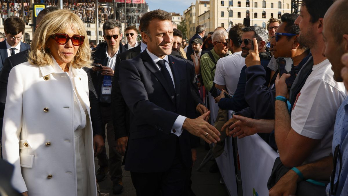 Emmanuel Macron shakes hands with spectators next to his wife Brigitte Macron during the Olympic Flame arrival ceremony. GETTY IMAGES