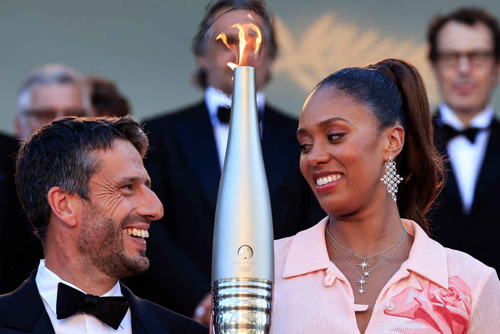 French basketball player Iliana Rupert holds the Olympic Torch next to Paris 2024 President Tony Estanguet in Cannes. GETTY IMAGES
