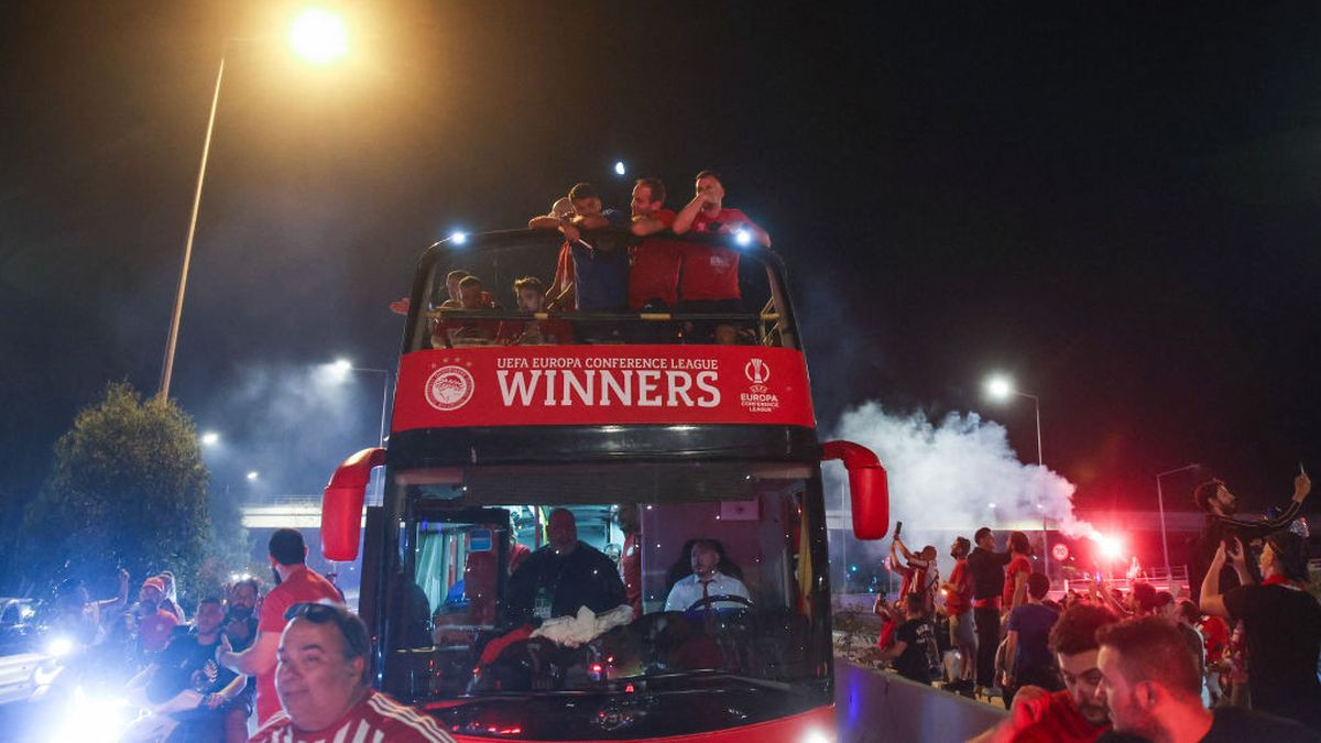 Supporters of Olympiakos FC cheer as they receive the team's players arriving on a bus in Piraeus on 30 May 2024. GETTY IMAGES