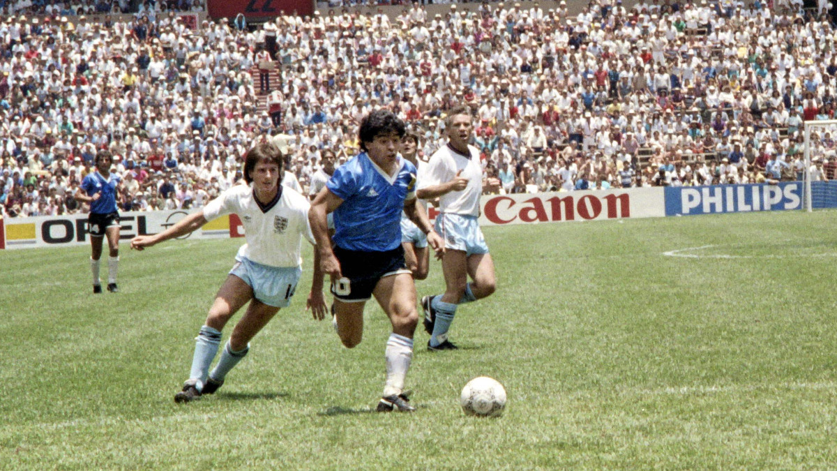 Diego Maradona dribbles past two English defenders on 22 June 1986 in Mexico City during the World Cup quarterfinal. GETTY IMAGES