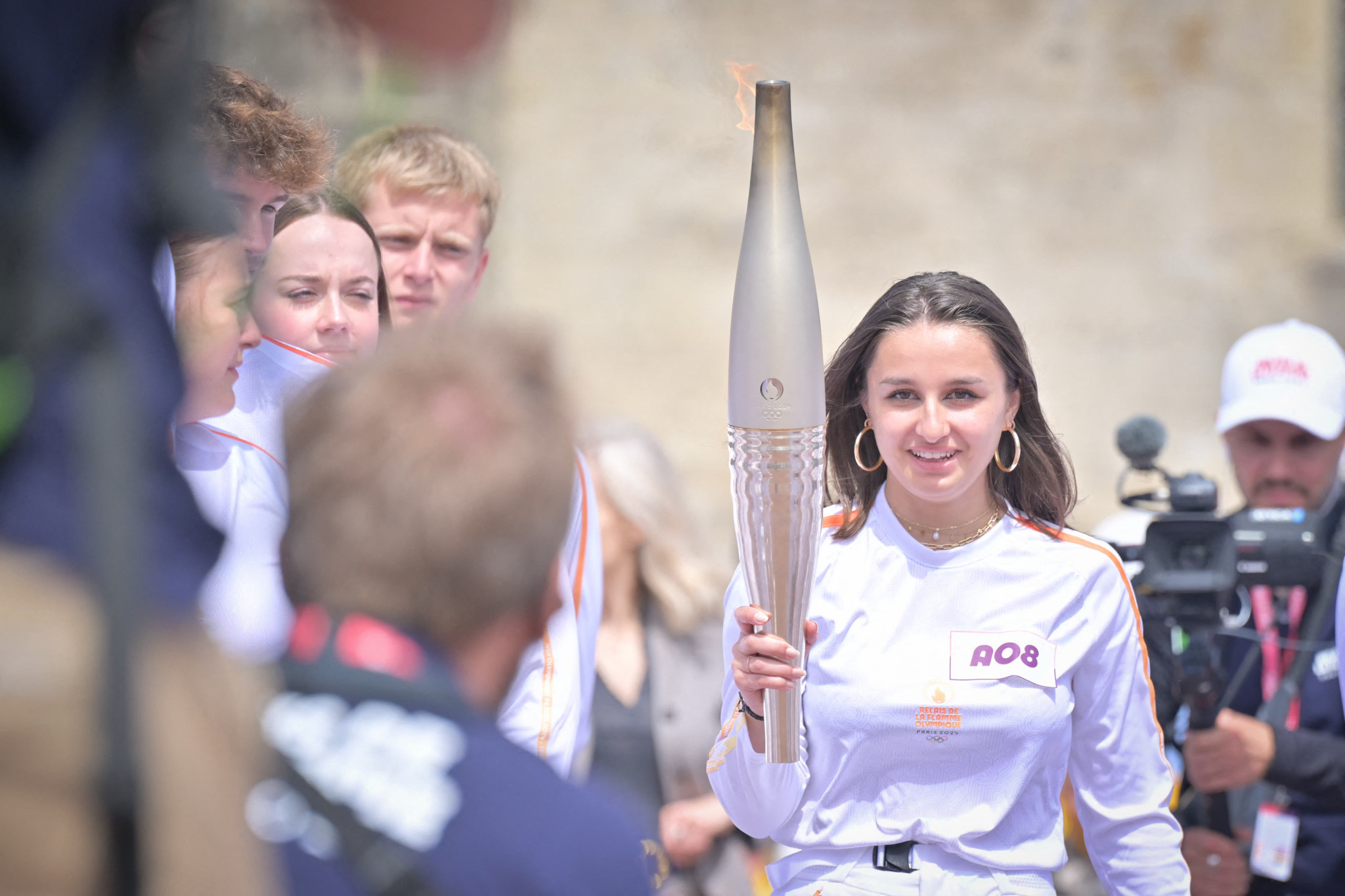 Torch bearer Fanny Rivallant holds the Olympic flame at Sainte-Mere-Eglise, Normandy. GETTY IMAGES