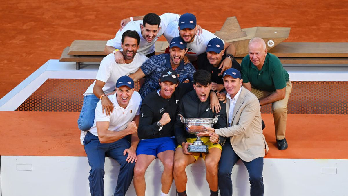Carlos Alcaraz reacts with the winners trophy alongside members of his team at Roland Garros on June 2024. GETTY IMAGES