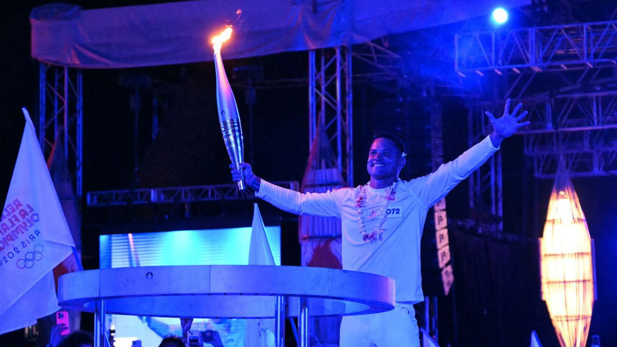 French surfer Michel Bourez holds the Olympic Torch in Place To'ata, Papeete. GETTY IMAGES