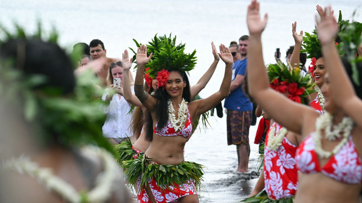 Dancers await the arrival of the Olympic flame during the Olympic torch relay in Mahina. GETTY IMAGES