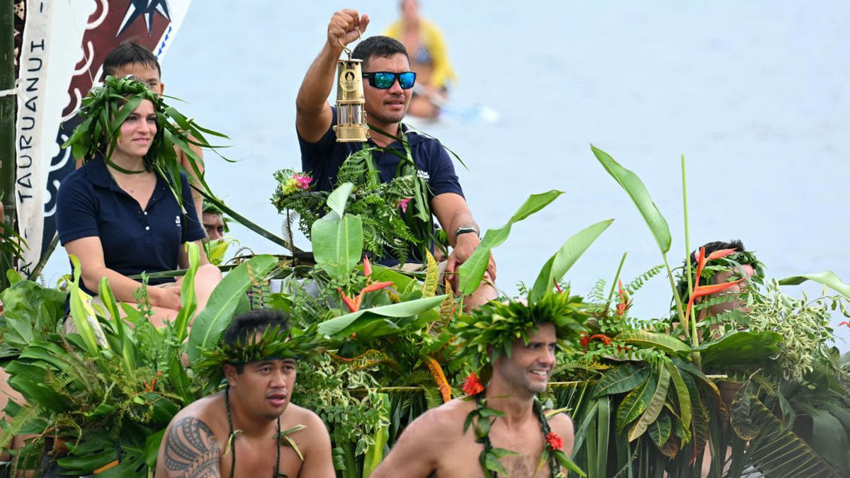 An official holds the Olympic flame as it arrives in Mahina, French Polynesia. GETTY IMAGES