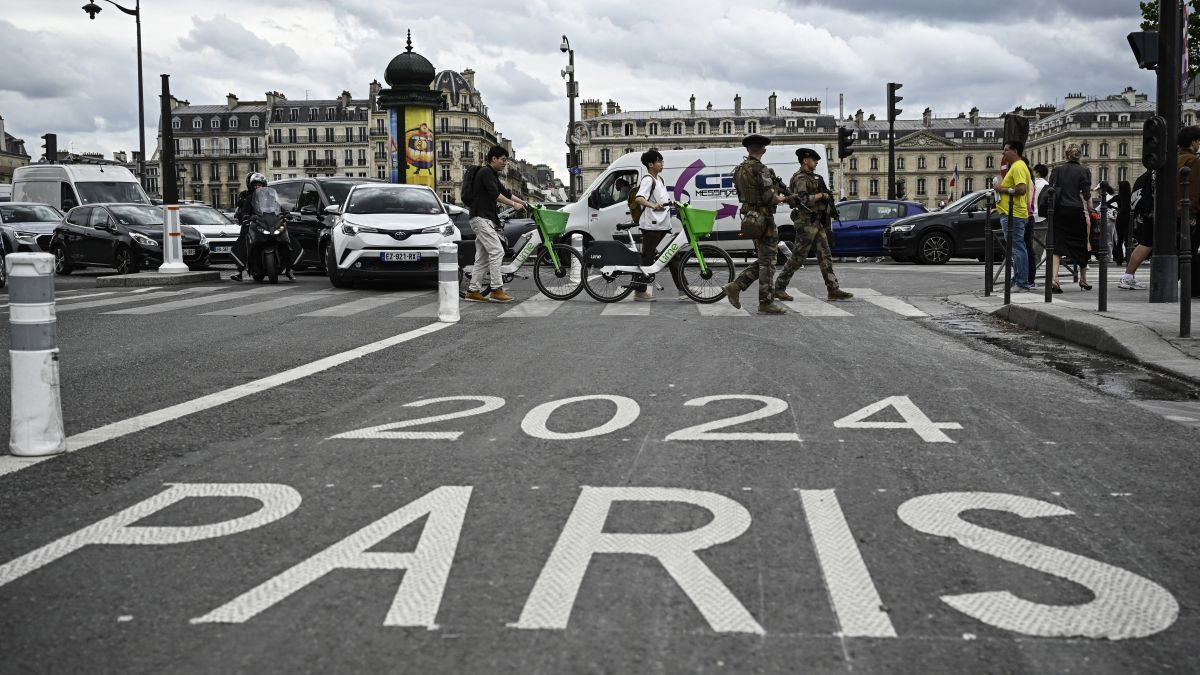 French soldiers patrol along a street past a road sign of a Paris 2024 lane for the upcoming Paris 2024 Olympics, in Paris. GETTY IMAGES
