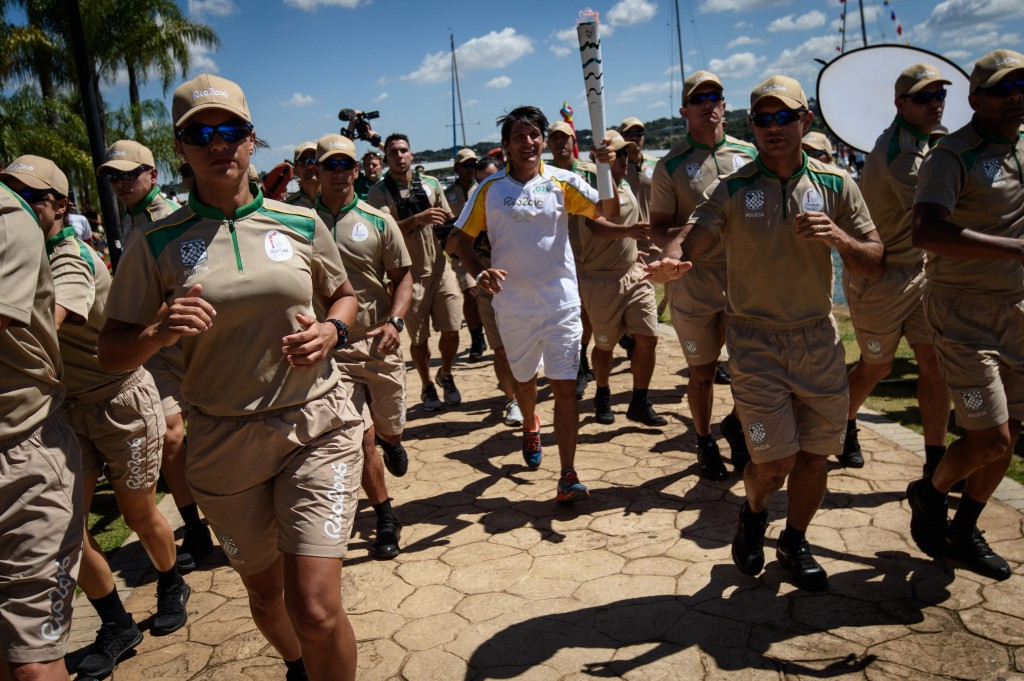 Triathlete Leandro Macedo carries the Olympic flame alongside Lake Paranoa ©Getty Images