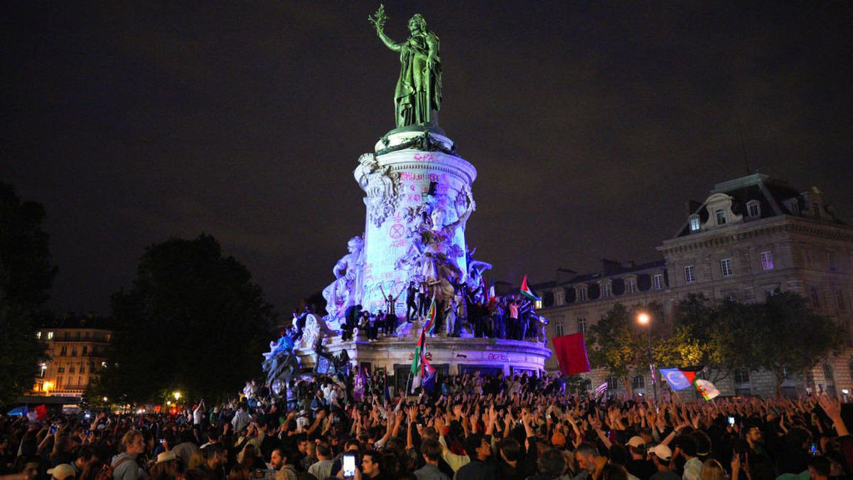 Demonstrators climb on the Monument a la Republique during a protest following the legislative election results in Paris. GETTY IMAGES