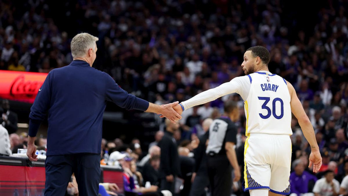 Stephen Curry and Steve Kerr shaking hands during an NBA game. GETTY IMAGES.