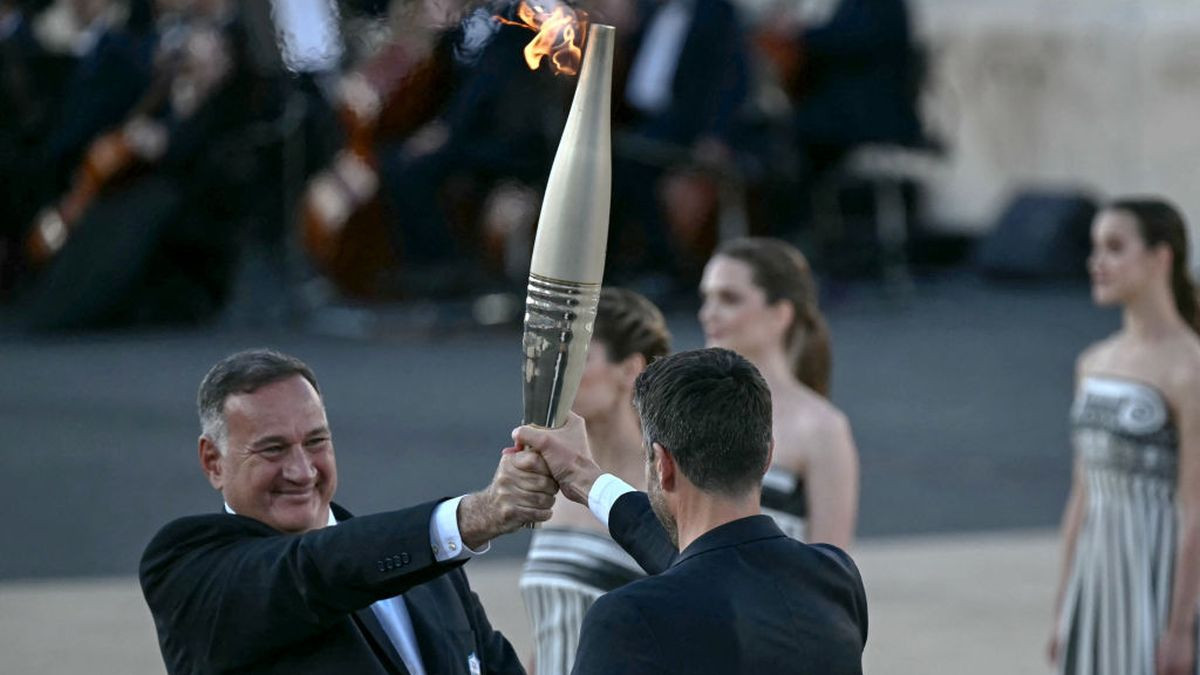 IOC member Spyros Capralos hands the Olympic torch to Tony Estanguet during the handover ceremony of the Olympic Flame on April 2024. GETTY IMAGES