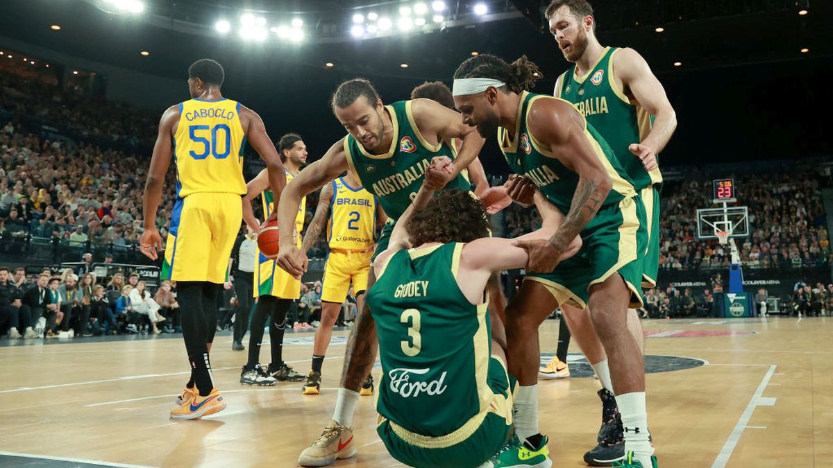 Boomers' captain Patty Mills helping a teammate. GETTY IMAGES