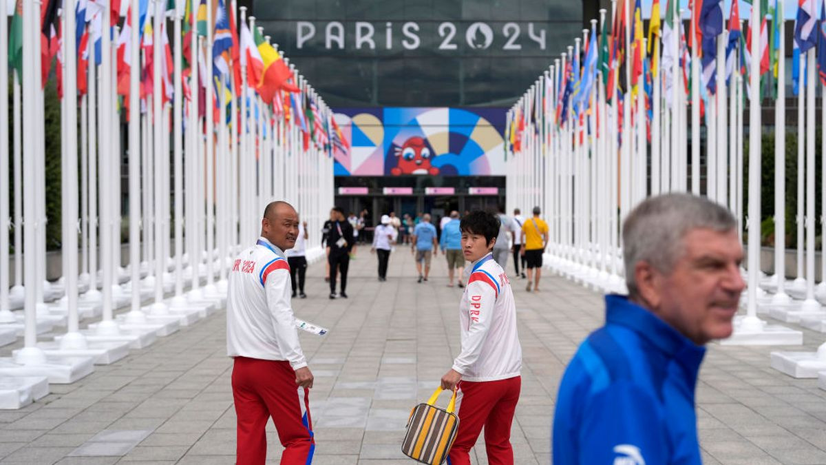 Members of the North Korean Olympic team look back as IOC President Thomas Bach tours the Olympic Village. GETTY IMAGES