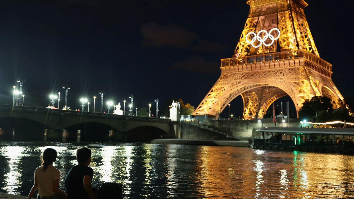 Spectators view the Eiffel Tower and Olympic rings along the Seine river. GETTY IMAGES 