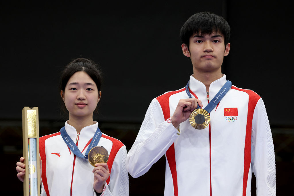 China's Huang Yuting and Sheng Lihao pose on the podium after winning the 10m mixed air rifle gold. GETTY IMAGES