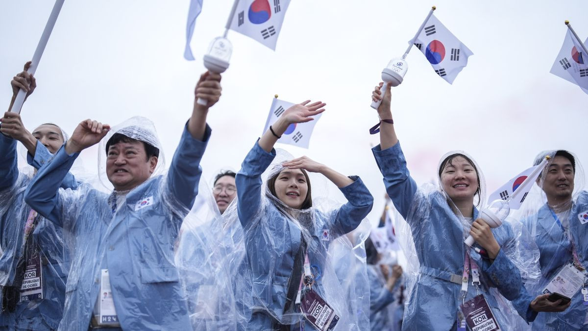  Members of Team South Korea wave their national flag on a boat on the River Seine during the opening ceremony. GETTY IMAGES