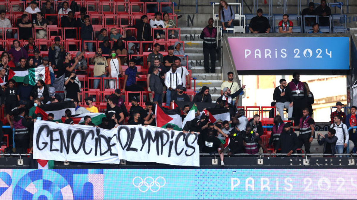 Fans hold a banner that reads 'Genocide Olympics' during the match between Israel and Paraguay. GETTY IMAGES