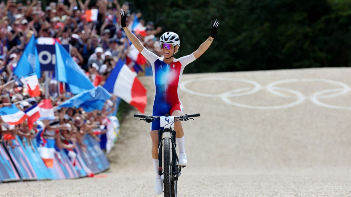 
Pauline Ferrand-Prevot raises her arms as she crosses the finish line as Olympic champion. GETTY IMAGES