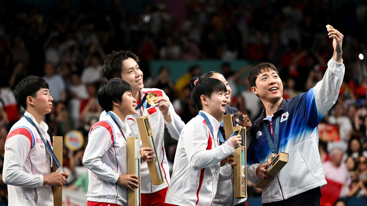 Bronze medalists South Korea's Lim Jonghoon takes a selfie picture with his mobile as he celebrates on the podium. GETTY IMAGES