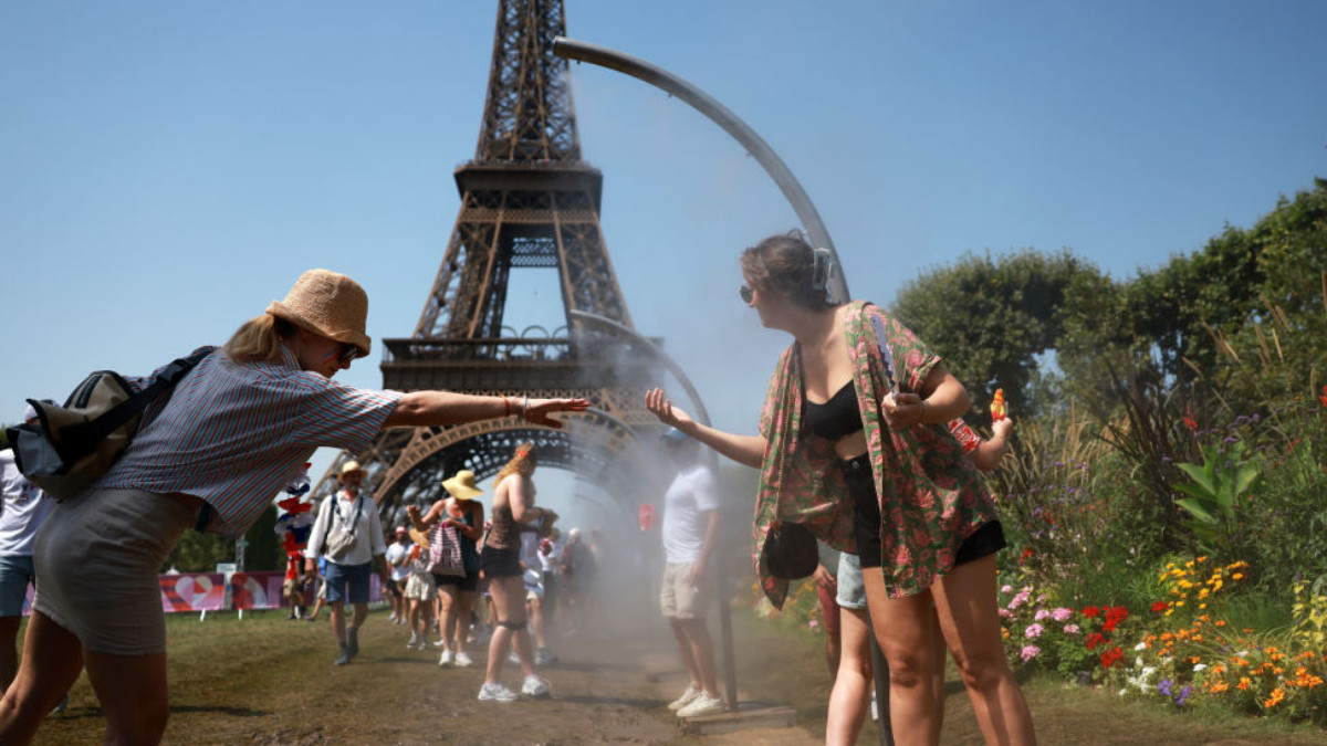 Spectators cool off under water misters in front of the Eiffel Tower on day four of the Paris 2024 on 30 July 2024. GETTY IMAGES
