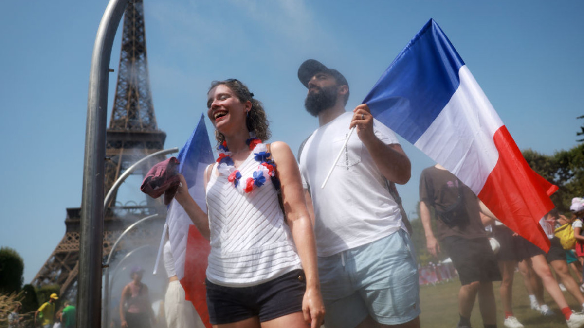 Spectators cool off under water misters in front of the Eiffel Tower in Paris. GETTY IMAGES 