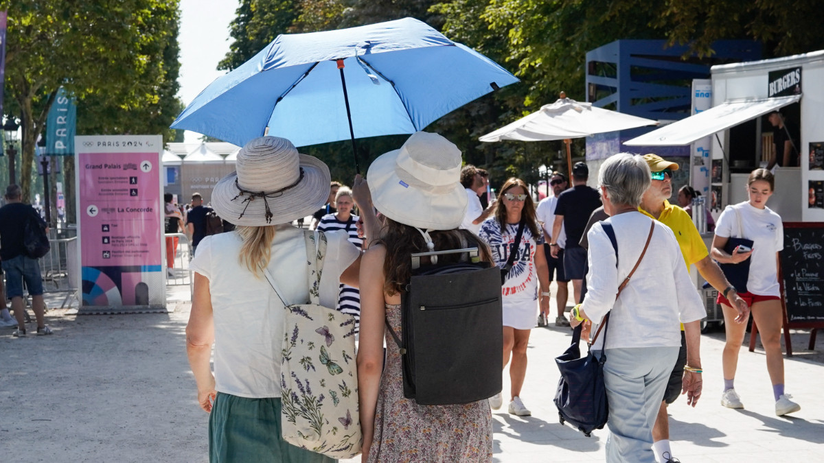 Tourists on a very hot day on the Champs Elysees during the Olympic Games in Paris on 30 July 2024. GETTY IMAGES