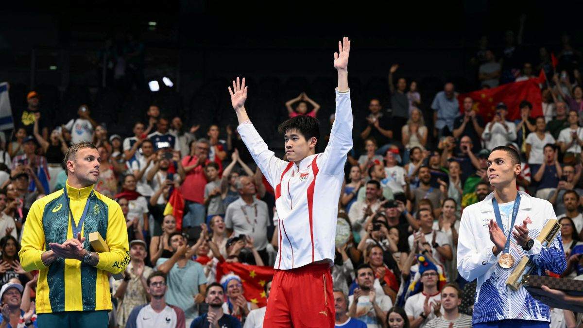 Zhanle celebrates on the podium of the men's 100m freestyle swimming event. GETTY IMAGES