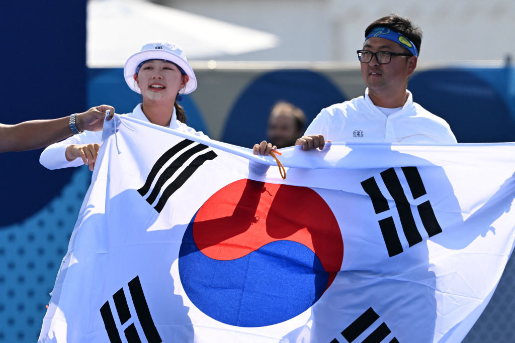 Kim Woojin (R) and Lim Sihyeon carry their national flag as they celebrate after winning the gold medal. GETTY IMAGES