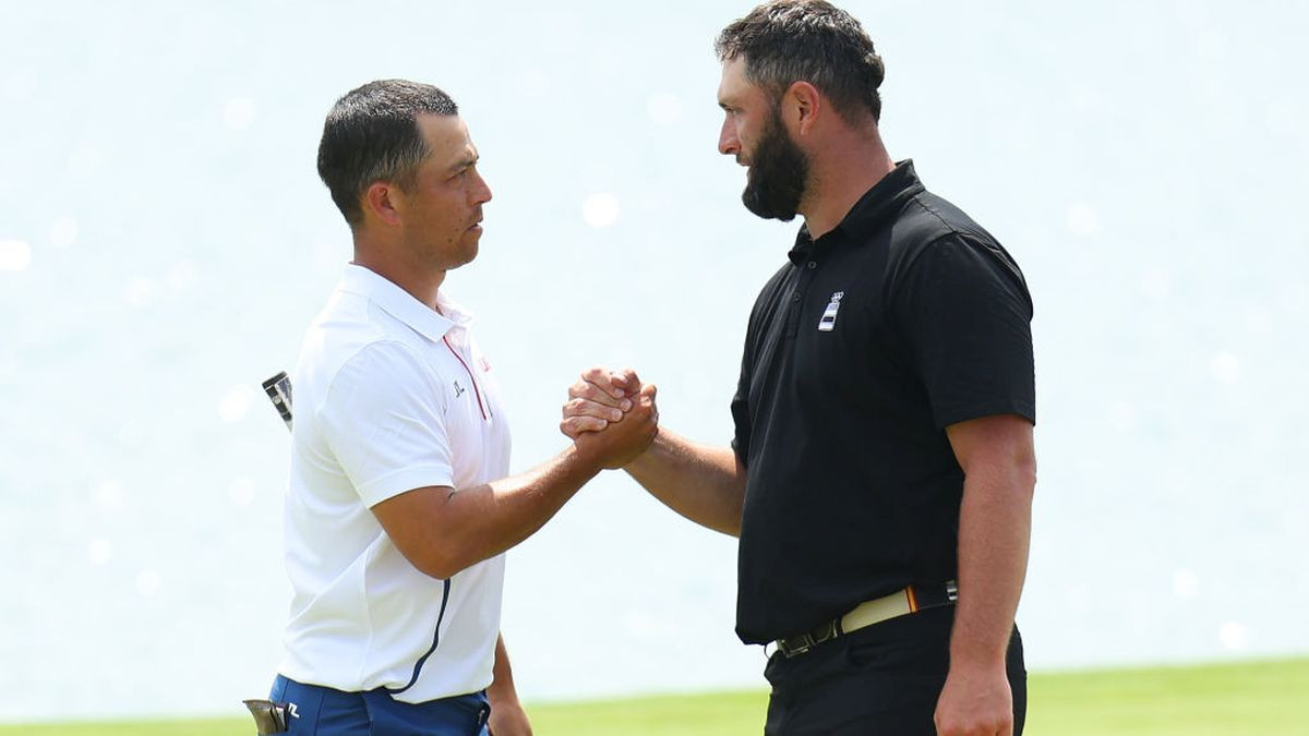 Xander Schauffele and Jon Rahm shake hands on the 18th green. GETTY IMAGES