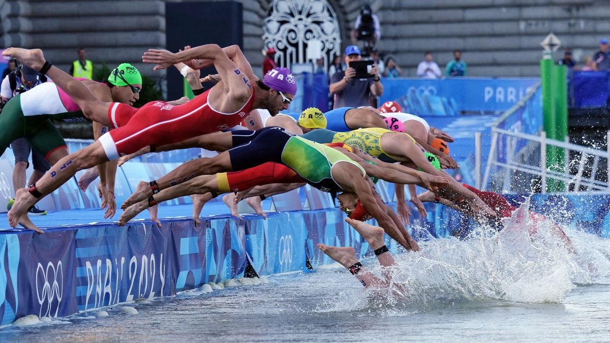 Athletes jump into the water to compete in the swimming race in the Seine. GETTY IMAGES