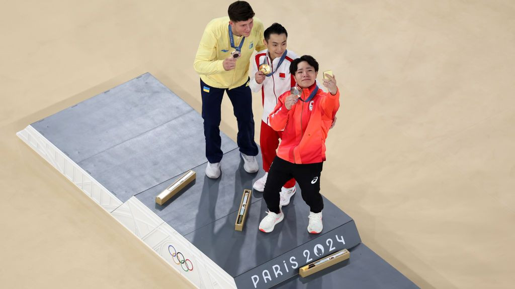 Gold medalist Jingyuan Zou of Team People's Republic of China (C), silver medalist Illia Kovtun of Team Ukraine (L) and bronze medalist Shinnosuke Oka of Team Japan (R) take selfie on the podium. GETTY IMAGES