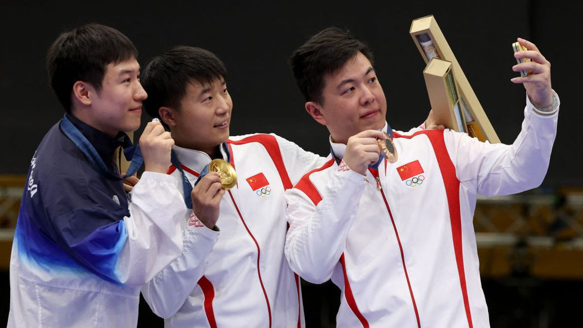 Cho Yeongjae, Li Yuehong and Wang Xinjie pose for a selfie on the podium. GETTY IMAGES