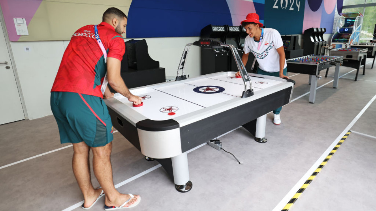 Athletes from Team Morocco play air hockey at a social room of the Athletes's Village. GETTY IMAGES