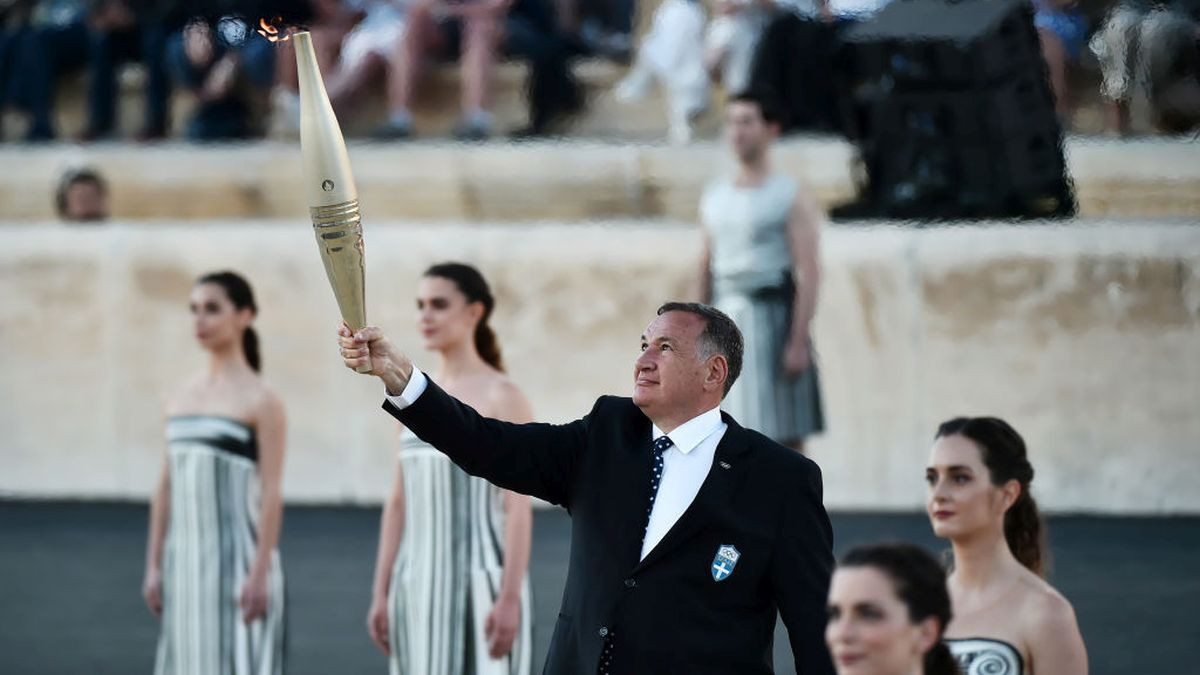 Spyros Capralos, President of the Hellenic Olympic Committee, holds the torch. GETTY IMAGES