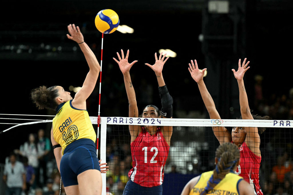 Brazil's #10 Gabriela Braga Guimaraes spikes the ball as US' #12 Jordan Thompson jumps to block. GETTY IMAGES