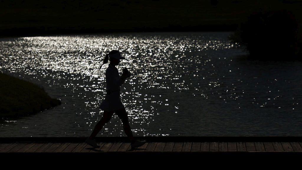 Lydia Ko of Team New Zealand (obscured) walks over a bridge to the 18th green during Day Three of the Women's Individual Stroke. GETTY IMAGES