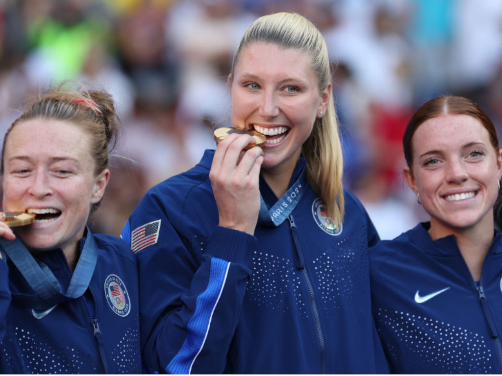  Casey Murphy of Team United States celebrates on the podium with teammates during the Women's Football medal ceremony following the Women's Gold Medal match between Brazil and the United States. GETTY IMAGES