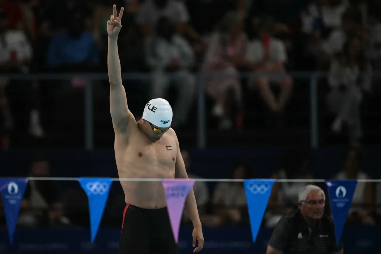 Palestinian swimmer Yazan Al Bawwab raises his arm with the flag over his heart before the men’s 100m backstroke. GETTY IMAGES