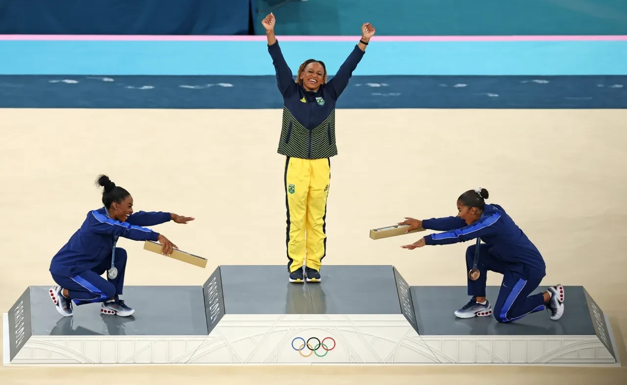 Simone Biles and bronze medalist Jordan Chiles hail gold medalist Rebeca Andrade. ELSA/GETTY IMAGES