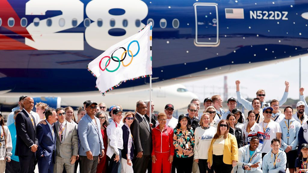 The LA28 team poses with Los Angeles Mayor Karen Bass, Long Beach Mayor Rex Richardson, Inglewood Mayor James T. Butts, and Team USA athletes as the Olympic Flag arrives to LA. GETTY IMAGES