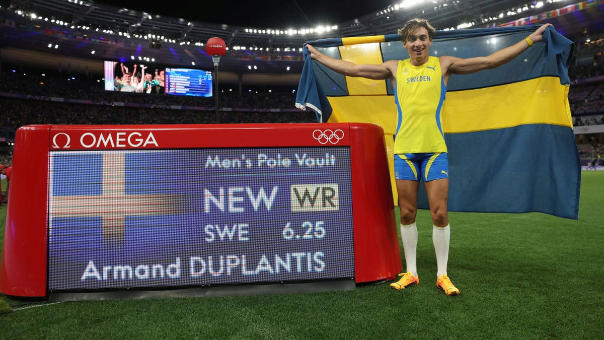 Duplantis poses in front of the scored board after setting a new world record. GETTY IMAGES