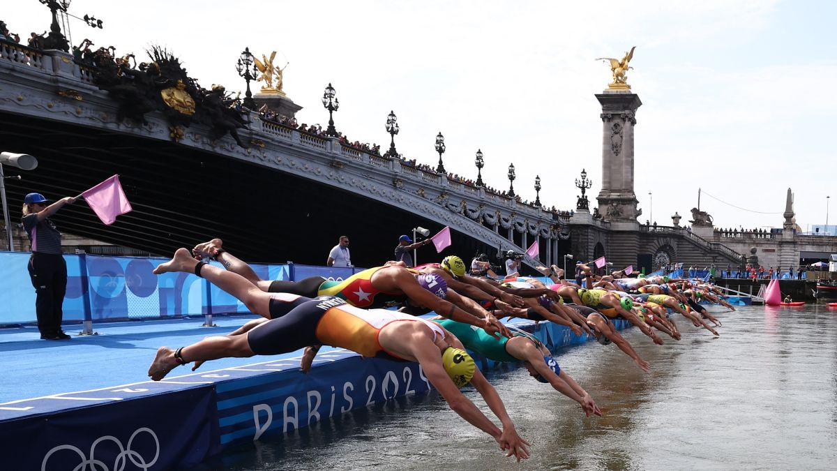 Athletes dive into the Seine river to start the swimming stage of the men's individual triathlon at the Paris 2024. GETTY IMAGES