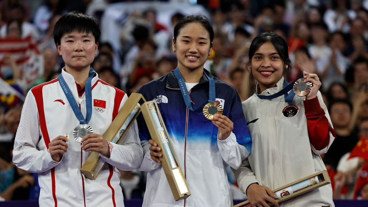 He Bing Jiao holds a Spain Olympic pin in the podium ceremony in remembrance of Carolina Marin, who withdrew due to an injury. GETTY IMAGES