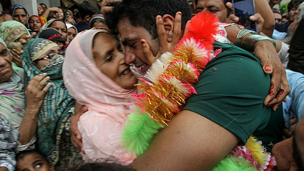 Pakistan's javelin gold medallist at the Paris 2024 Olympic Games, hugs his mother Raziah Parveen upon his arrival at his hometown . GETTY IMAGES