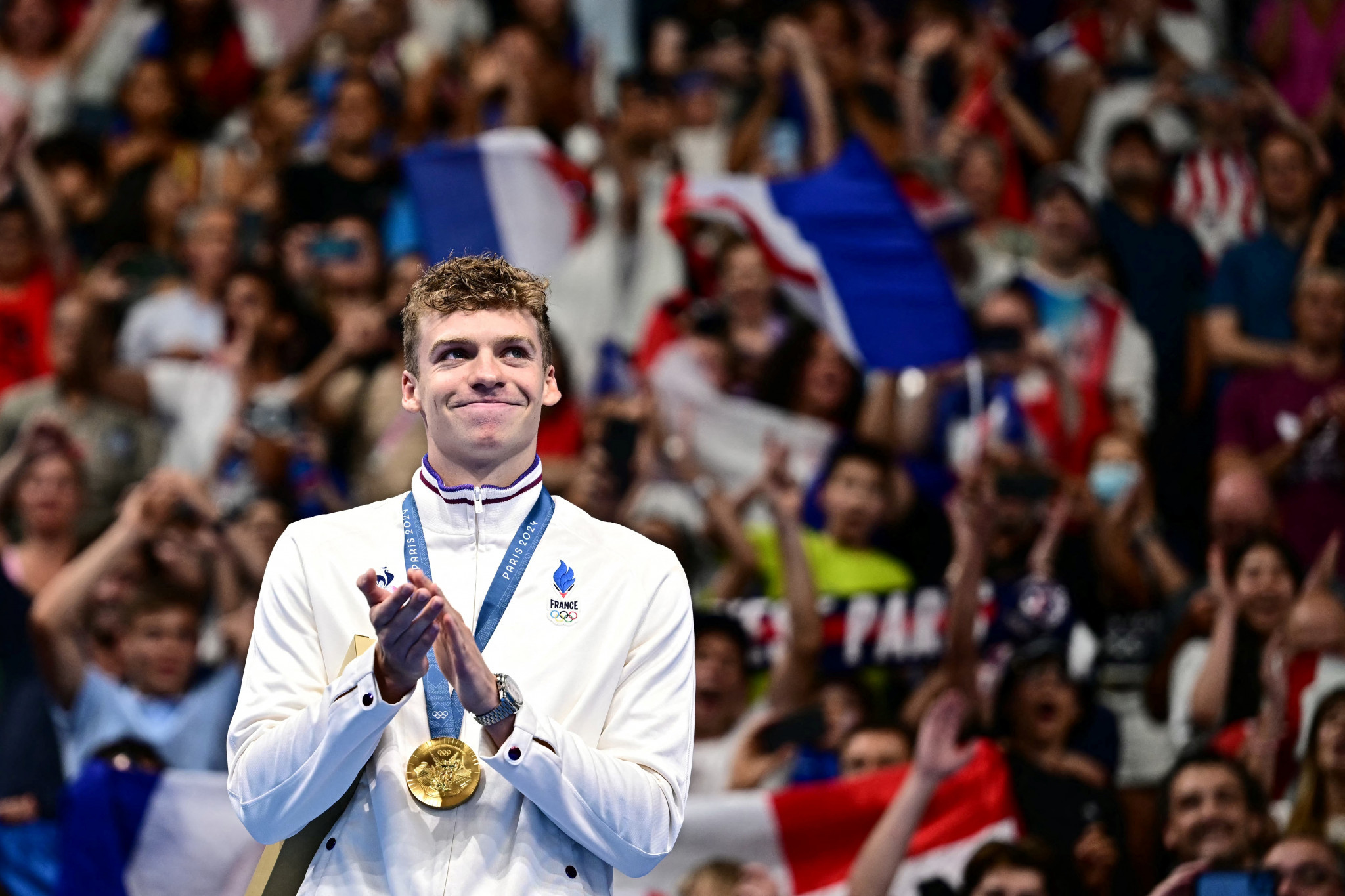 Gold medallist France's Leon Marchand on the podium of the men's 200m individual medley swimming event after winning gold at the Paris 2024 Olympic Games. GETTY IMAGES