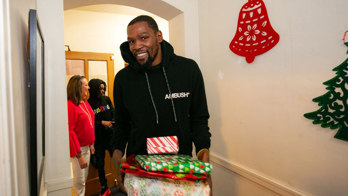 Durant giving Christmas gifts to families at Elizabeth House in Oakland. OAKEHOUSE