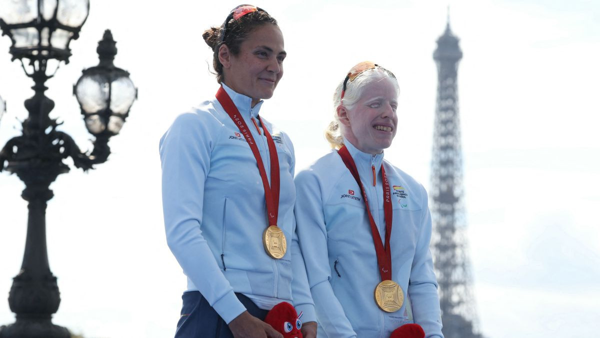 Gold medallist Spain's Susana Rodriguez (R) and her guide Sara Perez Sala celebrate during the victory ceremony for the women's PTVI para triathlon event at the Paris 2024 Paralympic Games. GETTY IMAGES