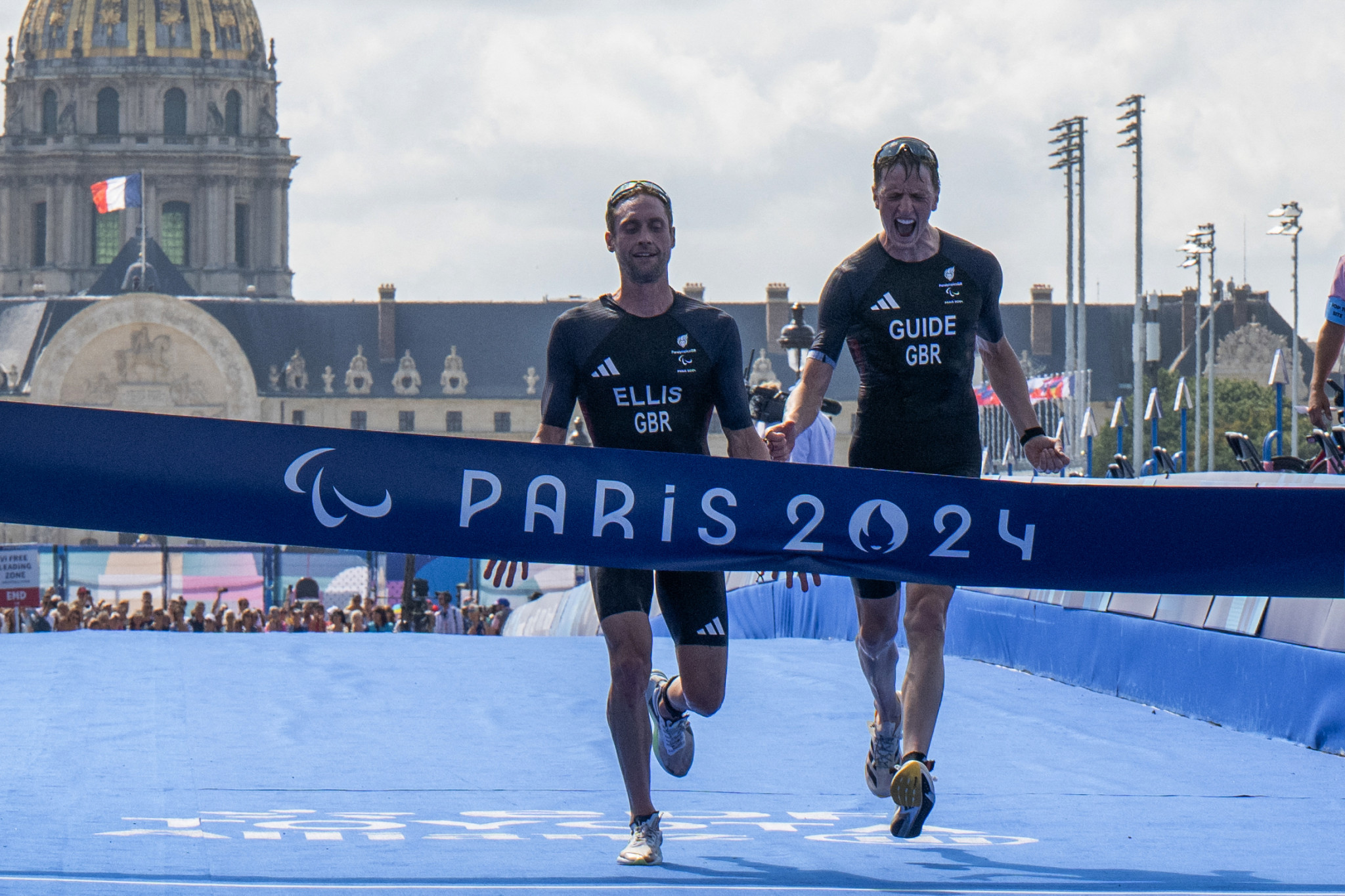 Dave Ellis and guide Luke Pollard cross the finish line of the Para Triathlon men's PTVI event to secure gold at the Paris 2024 Paralympic Games. GETTY IMAGES