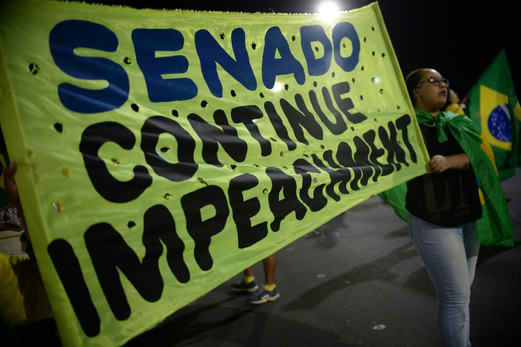 A banner calls on the Senate to continue with impeachment proceedings