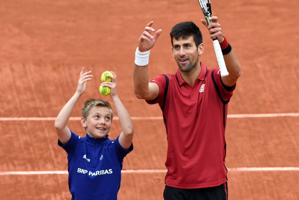Novak Djokovic celebrates his quarter-final victory over Czech Republic's Tomas Berdych with a ball boy ©Getty Images